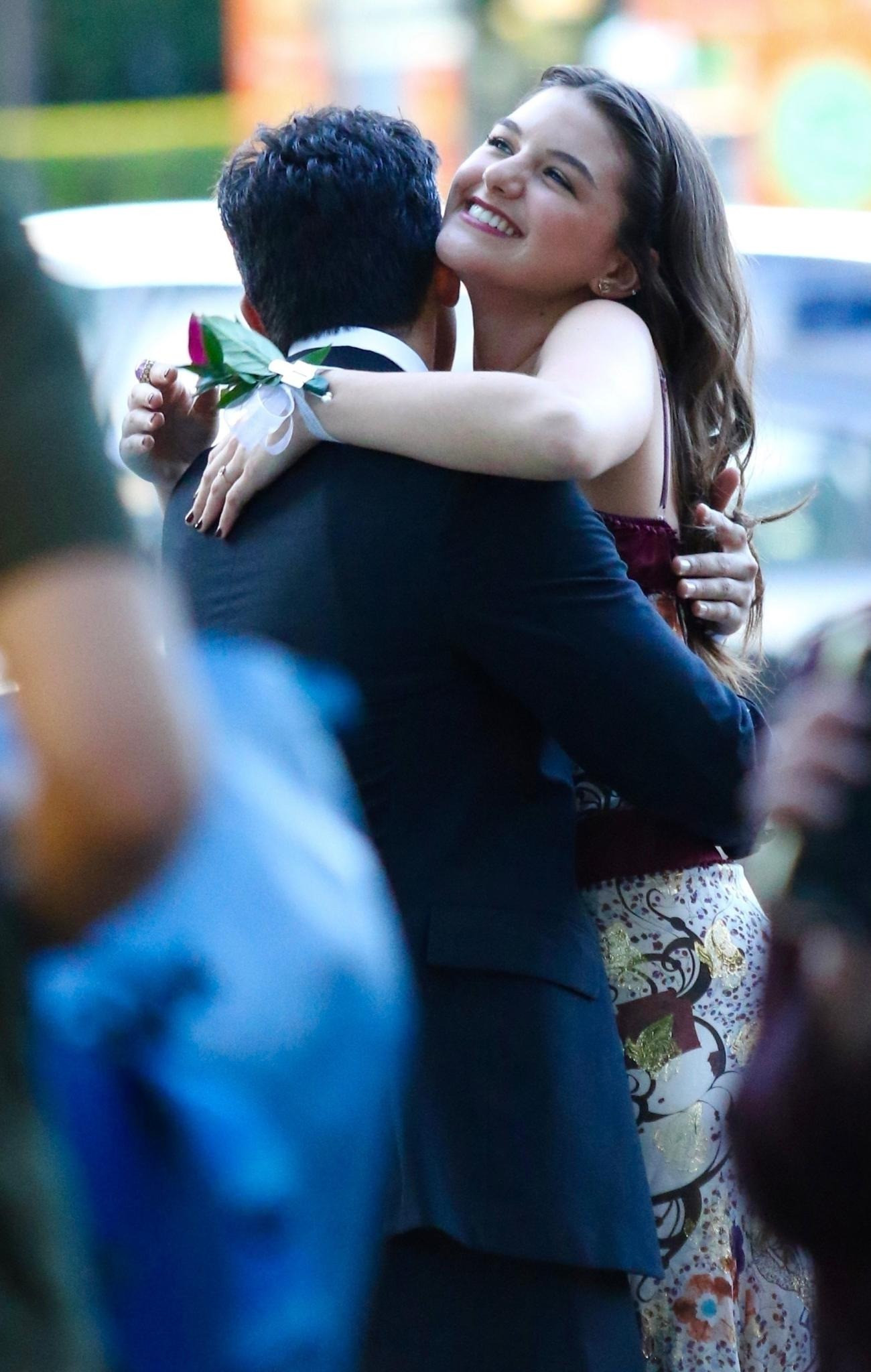 Suri tươi cười ôm một bạn nam. Đây dường như là cái ôm chào hỏi giữa những người bạn. Trong khi Suri đang trải qua những ngày tháng tươi đẹp nhất của tuổi trẻ, Tom Cruise bận quay phim ở London, Anh. Nam diễn viên không có vai trò gì trong quá trình trưởng thành của con gái.