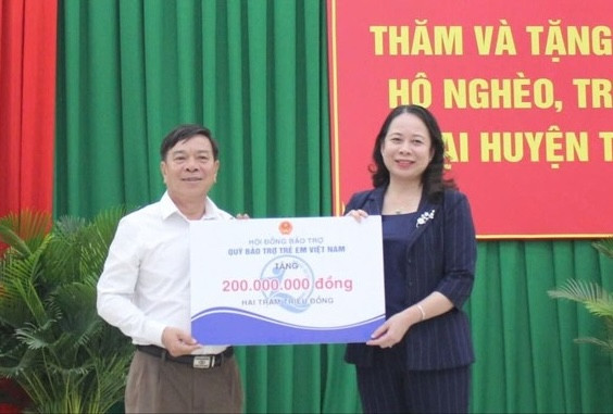 Phó Chủ tịch nước Võ Thị Ánh Xuân (ảnh phải) trao bảng tượng trưng 200 triệu đồng tặng Quỹ Bảo trợ trẻ em tỉnh Ninh Thuận. Ảnh: T.T.