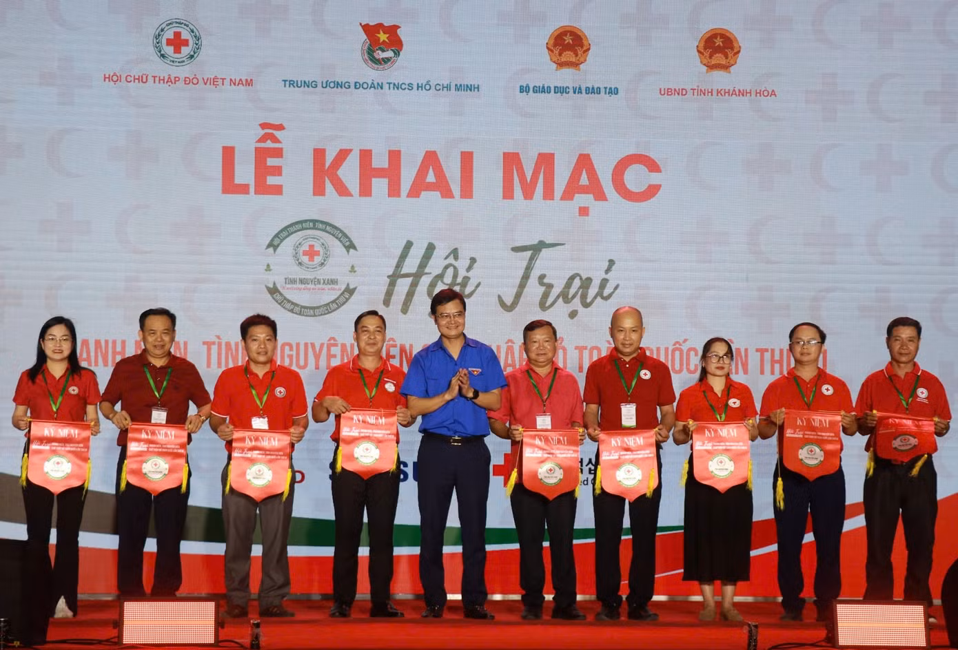 Anh Bùi Quang Huy (áo xanh) trao cờ lưu niệm cho các đại diện trại sinh tham gia Hội trại.