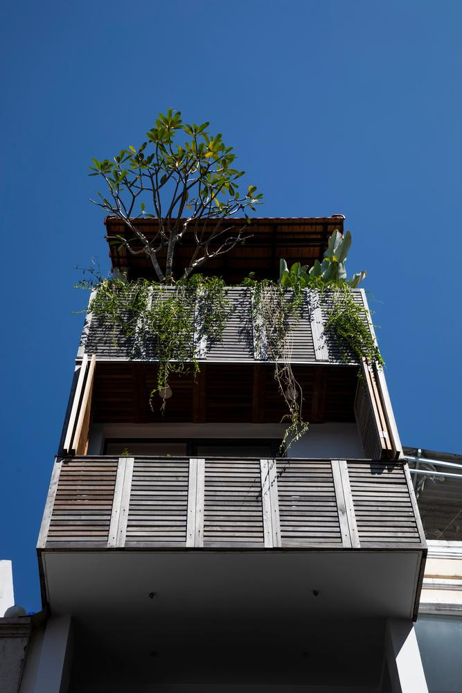 Hệ thống lưới gỗ tái chế và gạch xi măng gió giúp ngôi nhà “dễ thở” hơn. Những mảng vật liệu ốp mặt tiền cũng là giải pháp giúp ngôi nhà “hòa quyện” hoàn hảo trong bức tranh toàn cảnh phố phường.