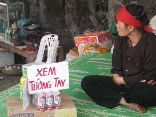 Một người đang chờ khách xem bói tại chùa Hương. Một người đang chờ khách xem tay tại chùa Hương