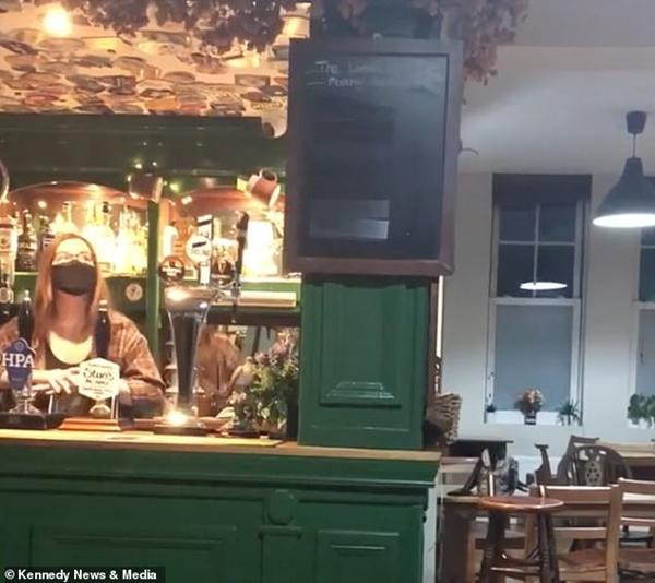 Một nhân viên của quán tỏ ra khó hiểu khi tấm bảng tự nhiên đung đưa. Ảnh: Kennedy News & Media. Một nhân viên của quán tỏ ra khó hiểu khi tấm bảng tự nhiên đung đưa. Ảnh: Kennedy News & Media.