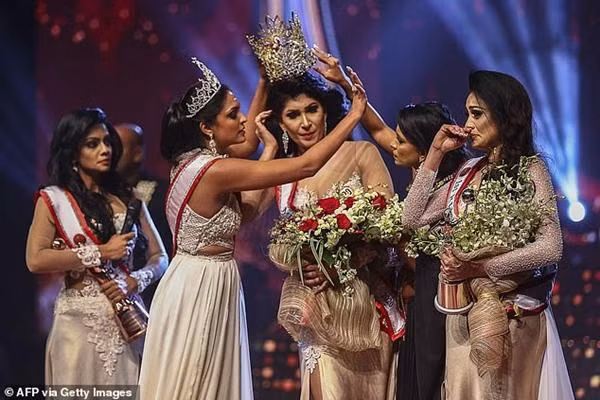 Caroline Jurie, 28 tuổi (người thứ hai từ bên trái), giật vương miện trên đầu của tân Hoa hậu Pushpika De Silva, 31 tuổi. Ảnh: AFP/ Getty Images.