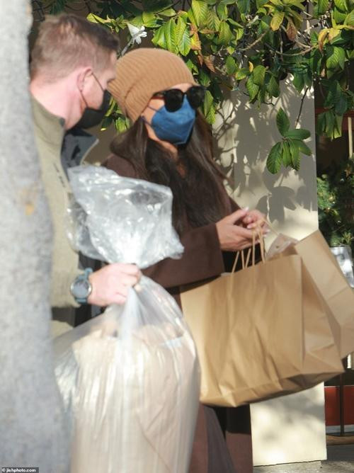 Meghan có vệ sĩ đi theo và người này giúp xách bớt một túi đồ. Ảnh: jishphoto.