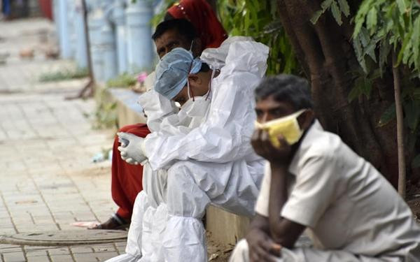 Một nhân viên y tế mặc đồ bảo hộ đang ngồi nghỉ trên lối đi của một bệnh viện công ở Kolkata. Ảnh: AFP. Một nhân viên y tế mặc đồ bảo hộ đang ngồi nghỉ trên lối đi của một bệnh viện công ở Kolkata. Ảnh: AFP.