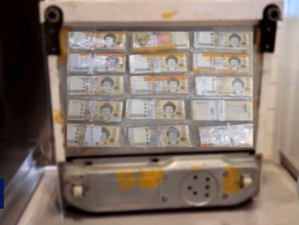 Nhiều tập tiền được dính bên dưới chiếc tủ lạnh cũ. Ảnh: MBC.