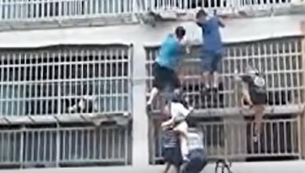 2 cô bé được những người hàng xóm chuyển từ tầng 3 xuống mặt đất. Ảnh: Trending in China. 2 cô bé được những người hàng xóm chuyển từ tầng 3 xuống mặt đất. Ảnh: Trending in China.