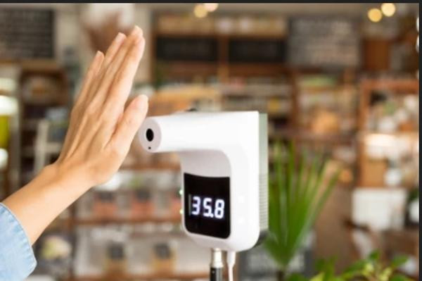 Nhiều công ty, trung tâm thương mại lắp máy đo thân nhiệt ở cửa. Ảnh minh họa: Shutterstock.