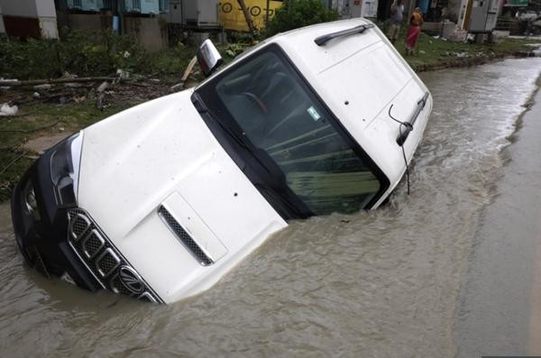 Một chiếc ô tô bị nhấn chìm khi bão Yaas đổ bộ tại Digha. Ảnh: EPA.