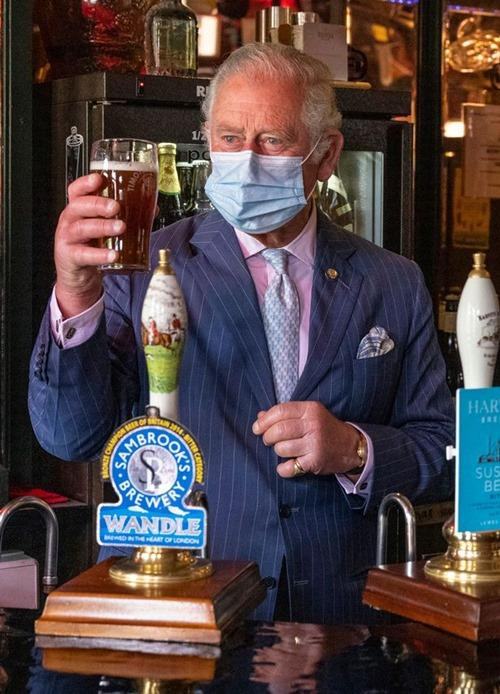 Thái tử Charles trong bức ảnh mới, khi ông tới thăm một nhà hàng và mua một cốc bia - bàn tay và những ngón tay ông như bị sưng phồng. Ảnh: Getty. Thái tử Charles trong bức ảnh mới, khi ông tới thăm một nhà hàng và mua một cốc bia - bàn tay và những ngón tay ông như bị sưng phồng. Ảnh: Getty.