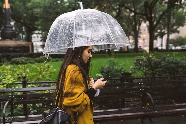 Dùng điện thoại khi đi dưới trời mưa có thể là việc rất nguy hiểm. Ảnh minh họa: Stocksy.