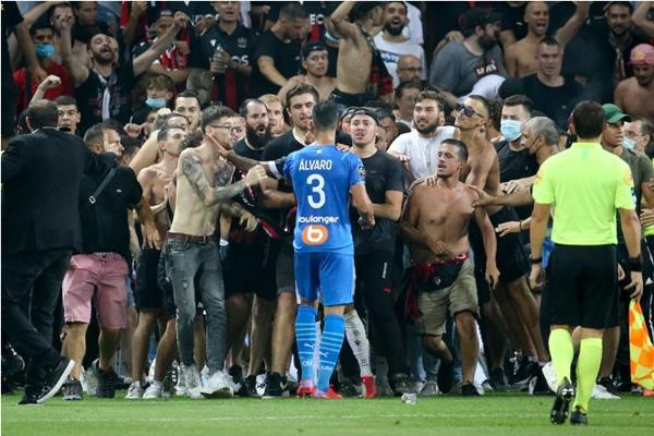 Cổ động viên tràn xuống sân để "ăn thua đủ" với các cầu thủ. Ảnh: John Berry.