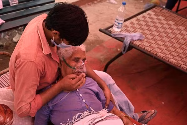 Một người đang cố gắng an ủi người thân nhiễm COVID-19, ngày 4/5. Ảnh: TAUSEEF MUSTAFA/ AFP/ Getty.