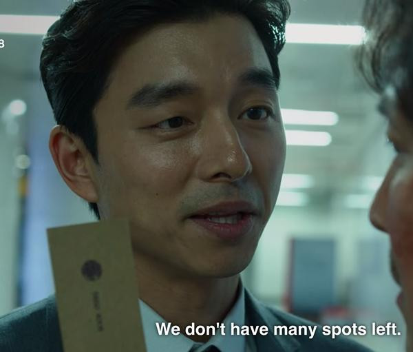 Diễn viên Gong Yoo giơ tấm danh thiếp trong phim. Ảnh: Netflix. Diễn viên Gong Yoo giơ tấm danh thiếp trong phim. Ảnh: Netflix.