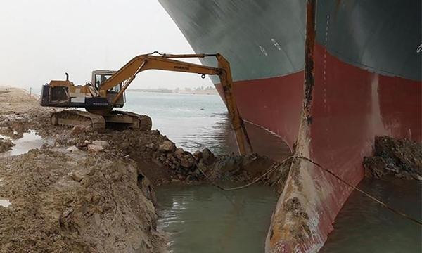 Chiếc máy xúc tí hon đang xúc bùn ở mũi tàu Ever Given. Ảnh: Cơ quan Quản lý Kênh đào Suez. Chiếc máy xúc tí hon đang xúc bùn ở mũi tàu Ever Given. Ảnh: Cơ quan Quản lý Kênh đào Suez.