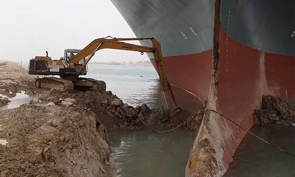 Chiếc máy xúc tí hon đang xúc bùn ở mũi tàu Ever Given. Ảnh: Cơ quan Quản lý Kênh đào Suez. Chiếc máy xúc tí hon đang xúc bùn ở mũi tàu Ever Given. Ảnh: Cơ quan Quản lý Kênh đào Suez.