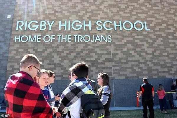 Học sinh đứng bên ngoài trường trung học Rigby, nơi họ được đưa đến để chờ phụ huynh đón. Ảnh: AP.