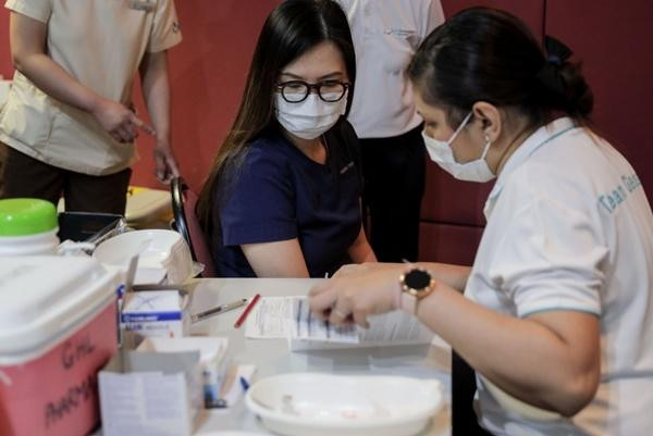 Người Singapore tiêm vắc-xin COVID-19. Ảnh: Wallace Woon/ EPA-EFE. Người Singapore tiêm vắc-xin COVID-19. Ảnh: Wallace Woon/ EPA-EFE.