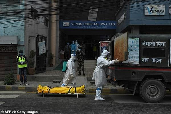 Nhân viên của quân đội Nepal đưa xác bệnh nhân COVID-19 đi hỏa táng. Ảnh: AFP/ Getty Images.