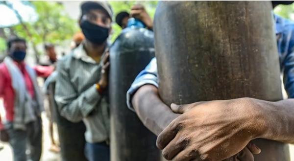 Người nhà của các bệnh nhân COVID-19 ở Kanpur đang đợi để được nạp những bình oxy rỗng. Ảnh: PTI.