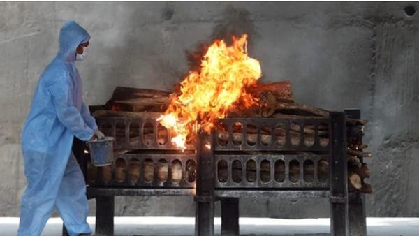 Một nhân viên tuyến đầu ở Ấn Độ đang đổ thêm chất lỏng dễ cháy vào một giàn thiêu để thiêu xác bệnh nhân COVID-19. Ảnh: Reuters. Một nhân viên tuyến đầu ở Ấn Độ đang đổ thêm chất lỏng dễ cháy vào một giàn thiêu để thiêu xác bệnh nhân COVID-19. Ảnh: Reuters.