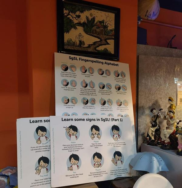 Tại quán có những hướng dẫn để mọi người học ngôn ngữ ký hiệu cơ bản. Ảnh: Facebook.