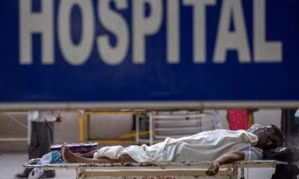 Một bệnh nhân COVID-19 đang đợi bên ngoài bệnh viện Guru Teg Bahadur (New Delhi). Ảnh: Reuters.
