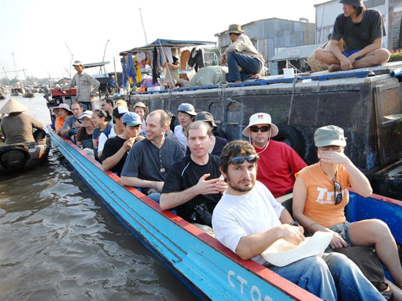 Du khách nước ngoài tại chợ nổi Cái Răng không được trang bị áo phao trong khi tàu chở quá tải. Ảnh: Tiến Tường