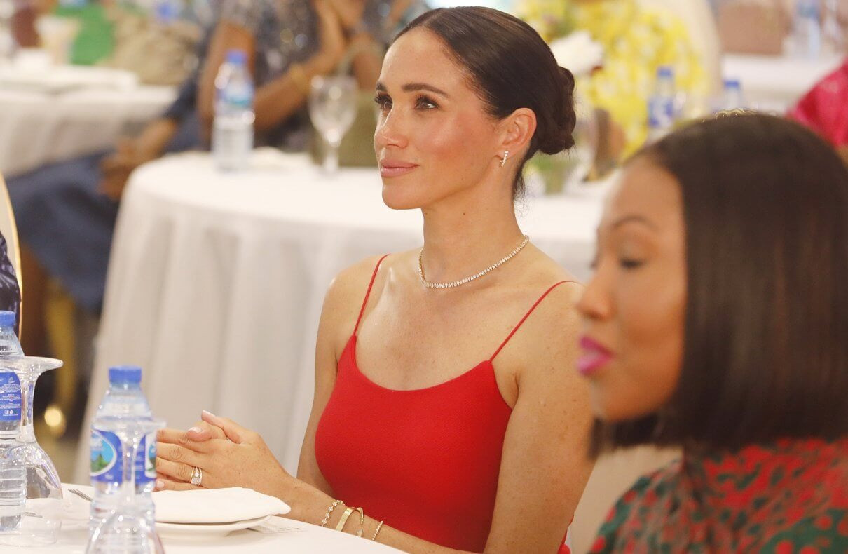 Điểm nhấn trong thời trang của Meghan ở Nigeria là chiếc váy hai dây màu đỏ tại sự kiện Women in Leadership do cô đồng tổ chức cùng Tiến sĩ Ngozi Okonjo-Iweala, Tổng Giám đốc Tổ chức Thương mại Thế giới, ở Abuja vào ngày 11/5. Thiết kế được sáng tạo bởi chuyên gia bản địa Oríré, có giá 332 USD. Đây là chiếc váy có tông màu rực rỡ nhất trong tủ quần áo chủ yếu màu trung tính của Nữ Công tước xứ Sussex. Ảnh: Getty Images.