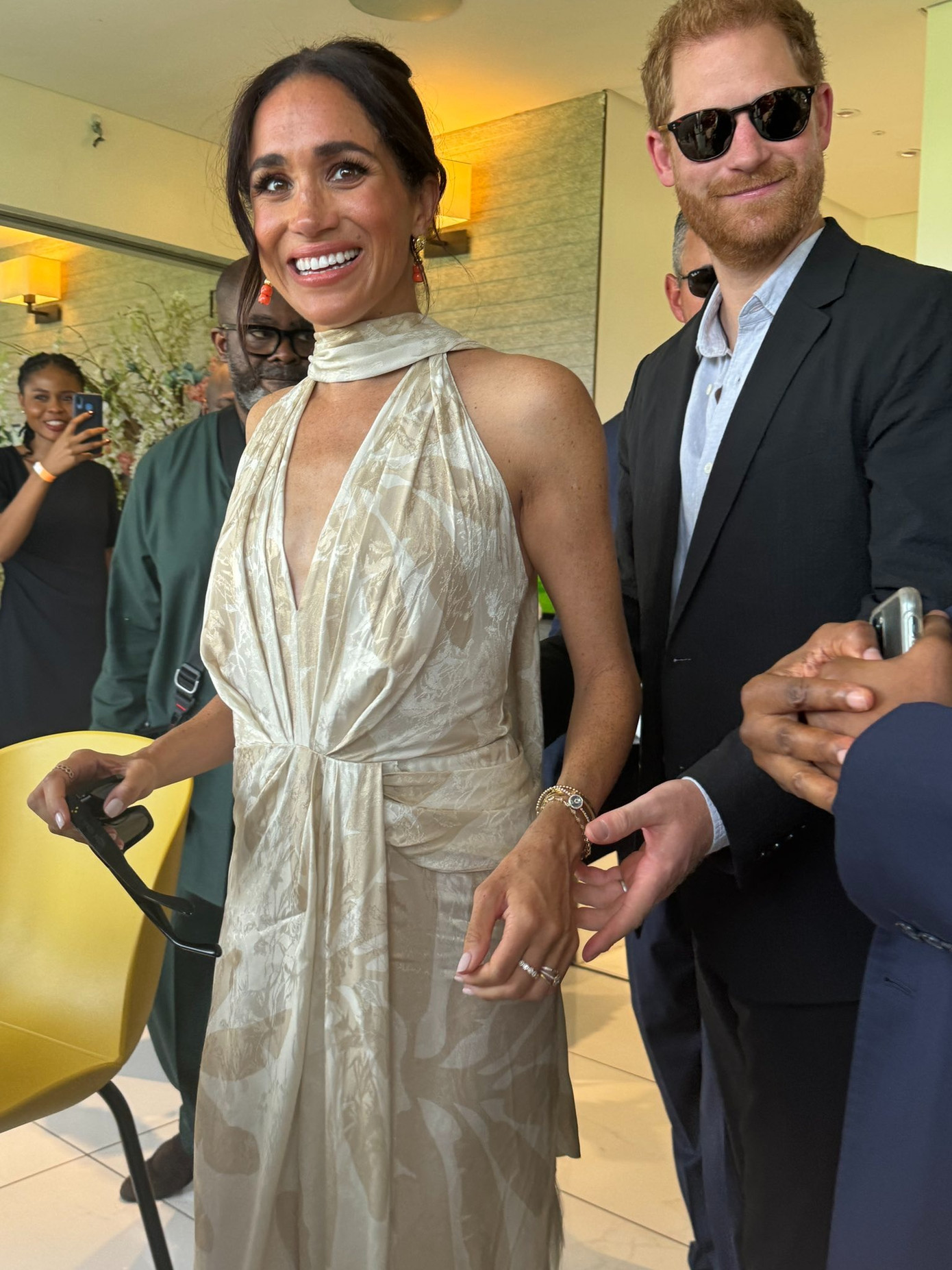 Vào ngày cuối ở Nigeria (12/5), Meghan mặc váy dây buộc cổ Summer Counts của Johanna Ortiz (1.995 USD), sandal Burberry và kính râm Heidi Merrick (215 USD) cùng chồng đến xem trận đấu polo từ thiện Nigeria Unconquered tại Câu lạc bộ Polo Lagos. Ảnh: X.