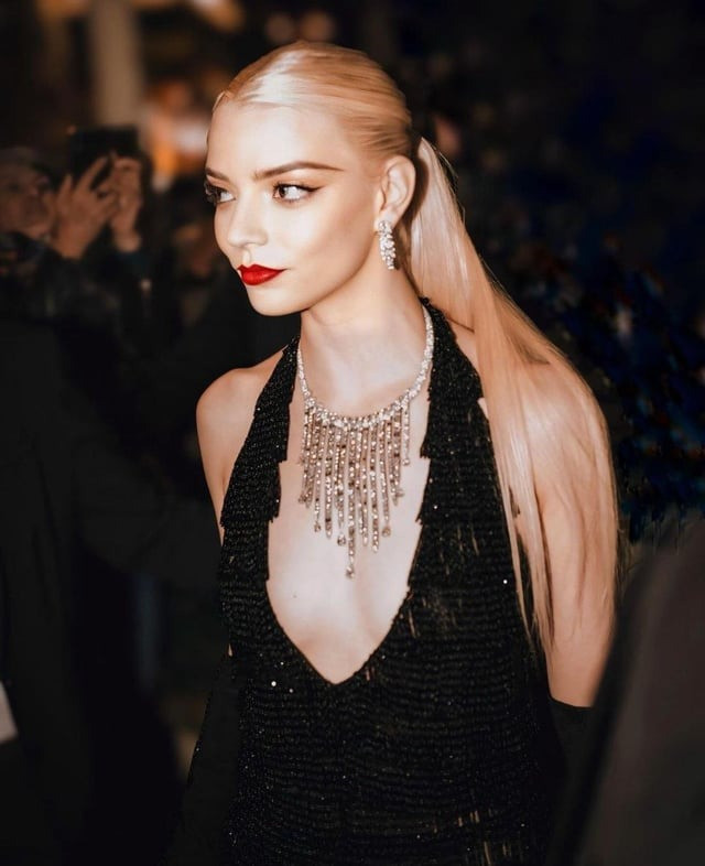 Kiểu trang điểm sắc sảo và khí chất lạnh lùng, kiêu kỳ cũng góp phần mang lại vẻ ngoài khó rời mắt của Anya. Tại bữa tiệc sau buổi công chiếu, nữ diễn viên trẻ chọn chiếc váy tua rua màu đen và dáng ngắn đến từ nhà mốt Dior. Đây là kiểu dáng phổ biến vào những năm 1920. Bất chấp đường xẻ ngực và vải xuyên thấu táo bạo, trang phục mặc lên người Anya vẫn rất sang. Ảnh: Reddit.