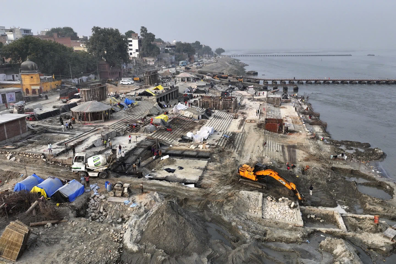 Một máy xúc đất đang làm việc trên bờ sông Hằng để chuẩn bị địa điểm cho lễ hội Kumbh Mela sắp tới. Ảnh: AP. Một máy xúc đất đang làm việc trên bờ sông Hằng để chuẩn bị địa điểm cho lễ hội Kumbh Mela sắp tới. Ảnh: AP.