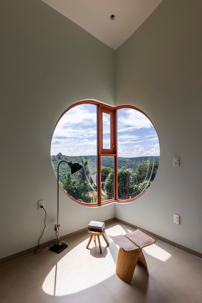 Cửa sổ lớn với hình dạng độc đáo đóng vai trò là điểm nhấn nổi bật, kết nối nội thất với cảnh quan xung quanh.