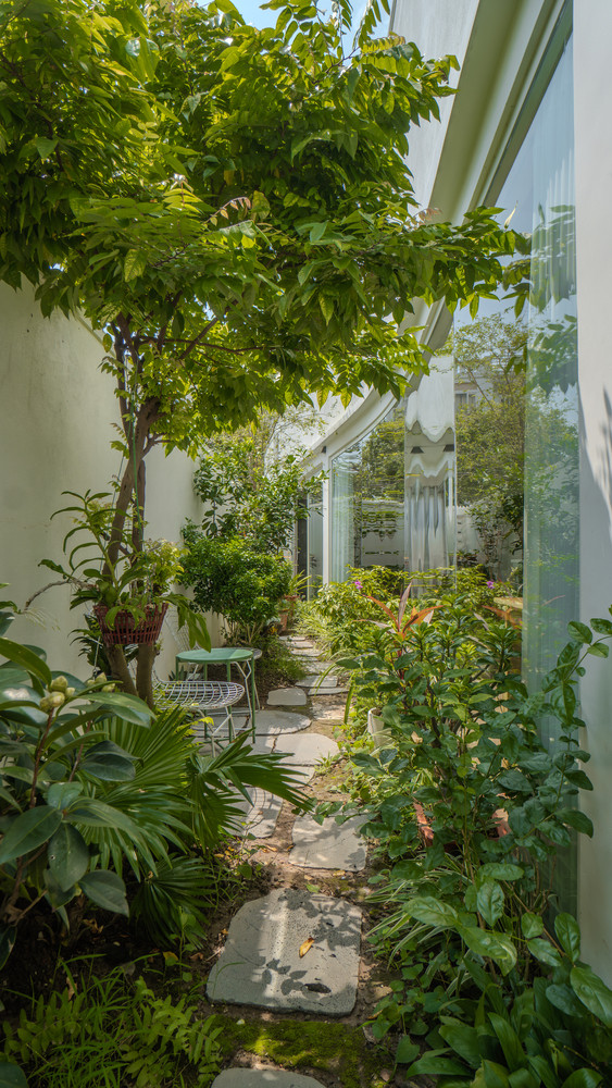 Để tạo ra một trải nghiệm thú vị, nuôi dưỡng mối liên hệ giữa con người và thiên nhiên trong không gian sống cho gia chủ, các kiến trúc sư đã tạo ra một khu vườn nhỏ với nhiều cây cối ở hai bên lối đi trong sân nhà.