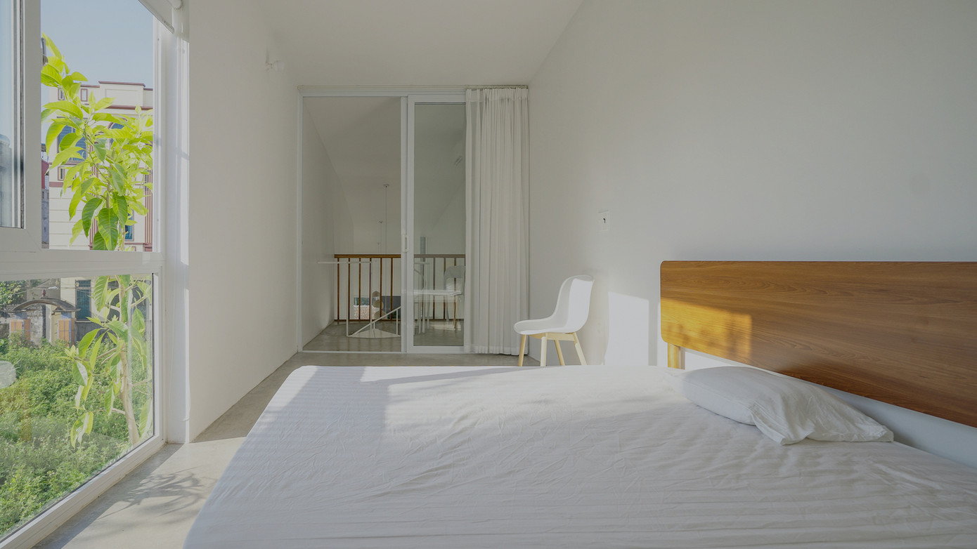 Phòng ngủ có giàn che nắng bằng cây xanh ở phía trước.