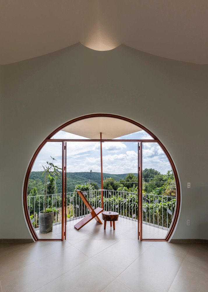 Cửa sổ lớn với hình dạng độc đáo đóng vai trò là điểm nhấn nổi bật, kết nối nội thất với cảnh quan xung quanh.