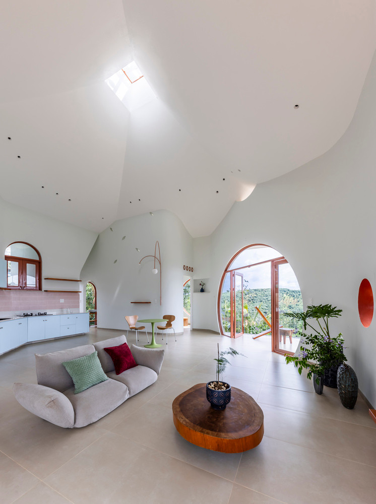 Trần nhà cong vươn lên duyên dáng đến đỉnh mái, nơi có "giếng trời" cho phép không gian bên trong kết nối trực tiếp với bầu trời.