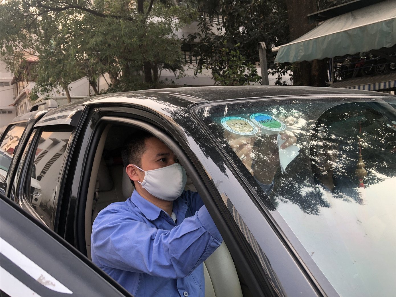 Đăng kiểm viên dán tem kiểm định cho xe. Ảnh: Hữu Chánh. Đăng kiểm viên dán tem kiểm định cho xe. Ảnh: Hữu Chánh.