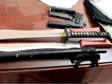 Cảnh sát thu giữ hung khí dao, mã tấu, bình xịt hơi cay và súng của băng nhóm gây án. Cảnh sát thu giữ hung khí dao, mã tấu, bình xịt hơi cay và súng của băng nhóm gây án