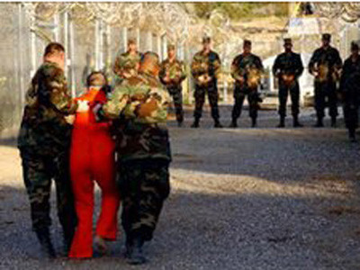 Binh sĩ Mỹ dìu một tù nhân ở Guantanamo 
