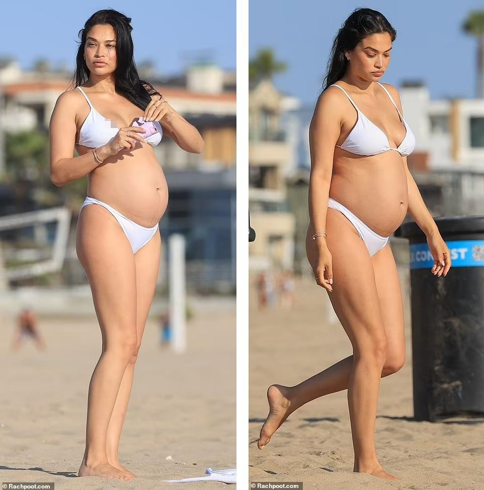 Shanina đang mang thai vẫn tự tin thả dáng với bikini bé xíu màu trắng. Ngoài bụng bầu "vượt mặt", thân hình của siêu mẫu nội y 31 tuổi không thay đổi nhiều. Trên trang cá nhân, cô vẫn thường nhiều đăng ảnh gợi cảm, có cả ảnh bán khỏa thân.