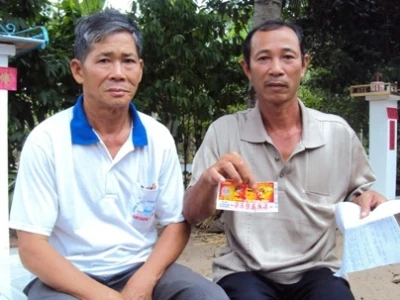 Ông Tùng (phải) và tấm vé số bị rách