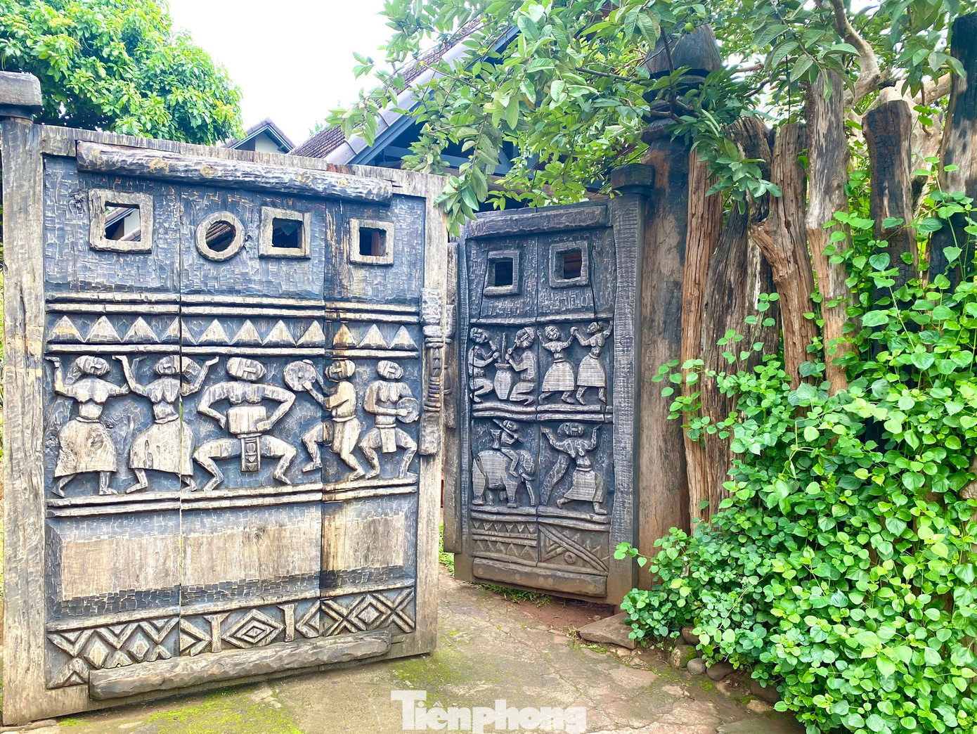 Cổng vào của một gia đình có họa tiết khắc những hoạt động, điệu múa thường ngày của người Ê đê