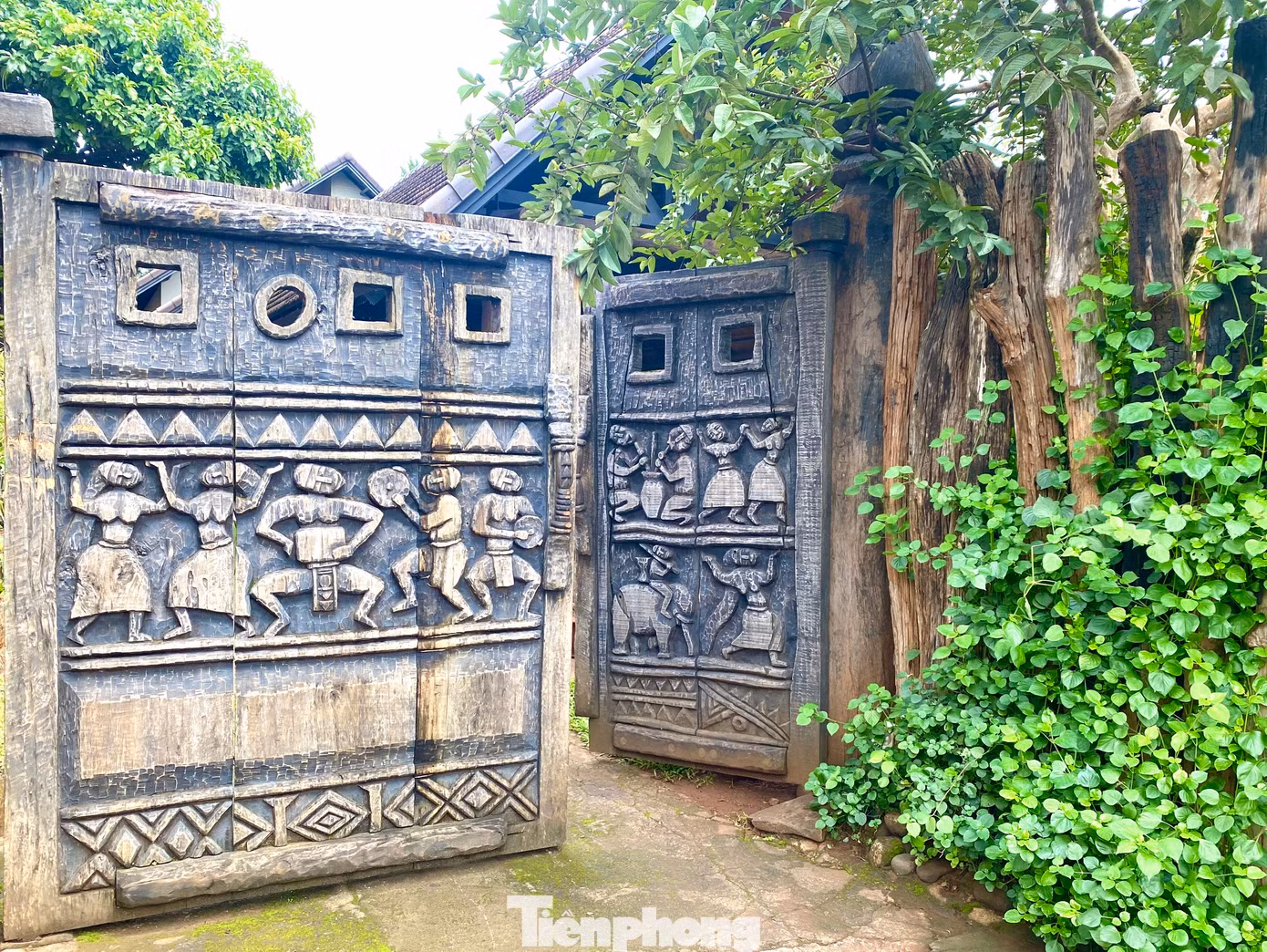 Cổng vào của một gia đình có họa tiết khắc những hoạt động, điệu múa thường ngày của người Ê đê