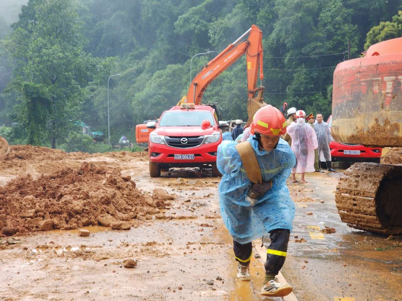 Do điều kiện thời tiết xấu, lực lượng chức năng gặp khó khăn trong việc tìm kiếm nạn nhân vụ sạt lở, cũng như di dời đất đá, khơi thông tuyến đường. Ảnh: D.P