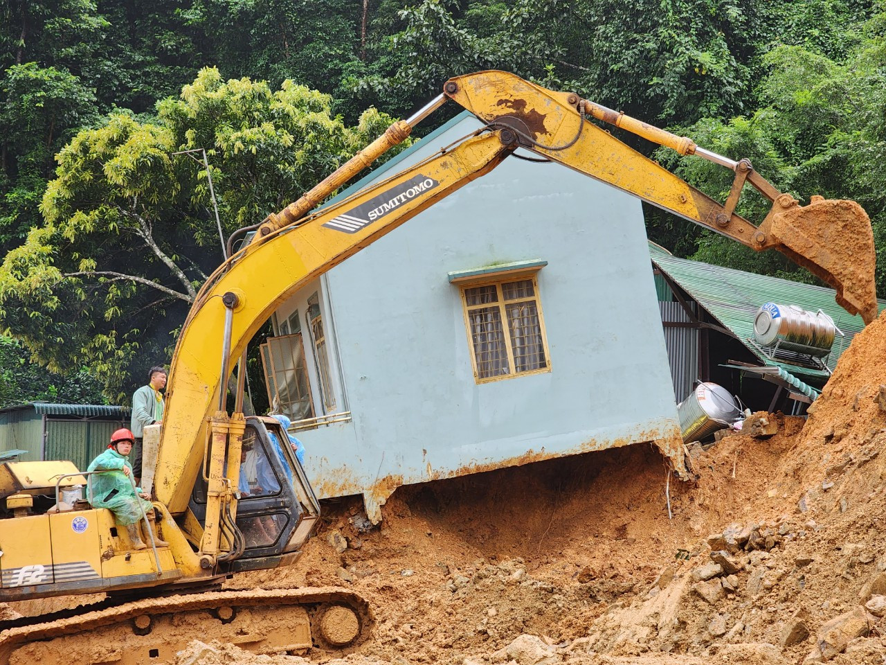 Đêm qua, lực lượng chức năng đã tìm thấy thi thể của 3 cán bộ chiến sỹ CSGT hy sinh. Trưa nay, các lực lượng đã tìm thấy thi thể nạn nhân cuối cùng. Trong ảnh: Một ngôi nhà bị đổ nghiêng bên đường, nhiều đất đá vùi lấp xung quanh. Ảnh: D.P