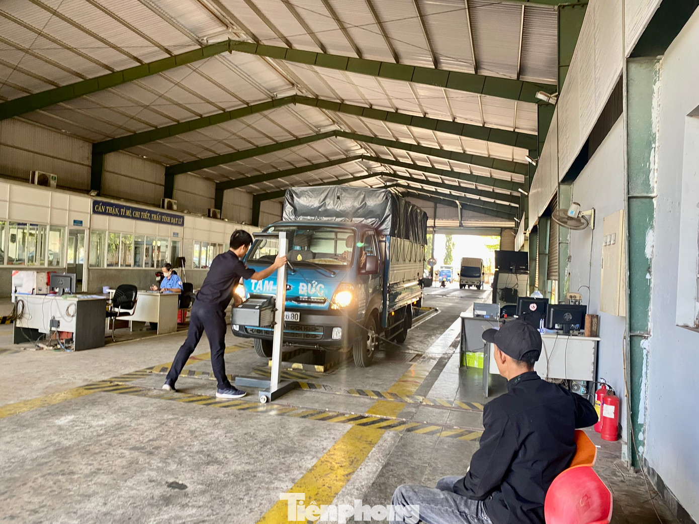 Nhân viên Trung tâm Đăng kiểm xe cơ giới 47-04D kiểm tra độ sáng của đèn một chiếc ô tô.