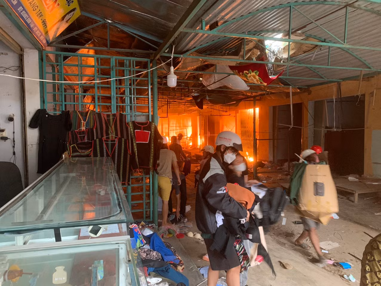 Lực lượng chức năng và người dân vận chuyển hàng hóa ra khỏi chợ. Ảnh: Sỹ Hạnh
