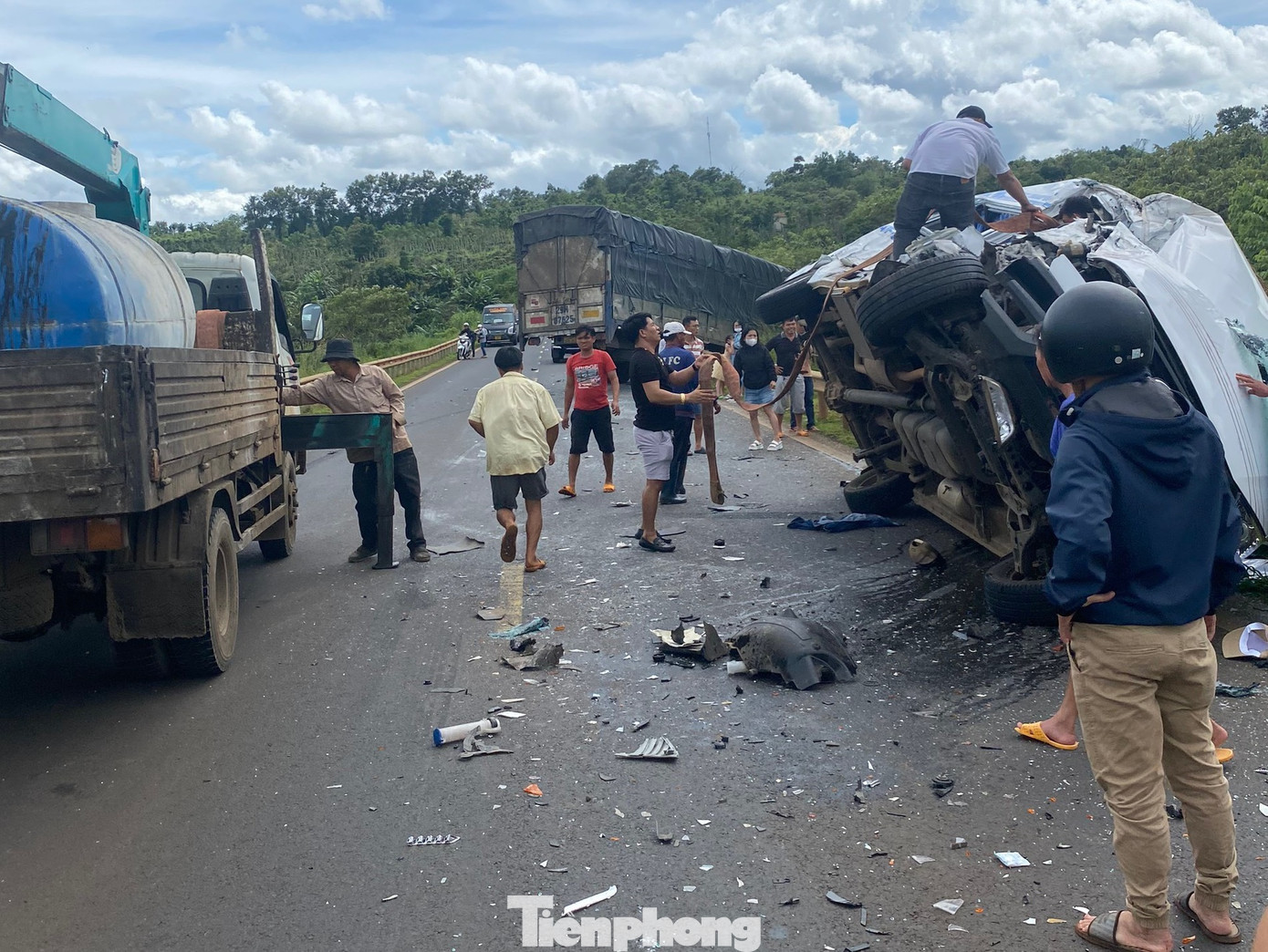 Người dân cùng lực lượng chức năng phá cửa đưa nạn nhân bị thương ra khỏi xe 16 chỗ