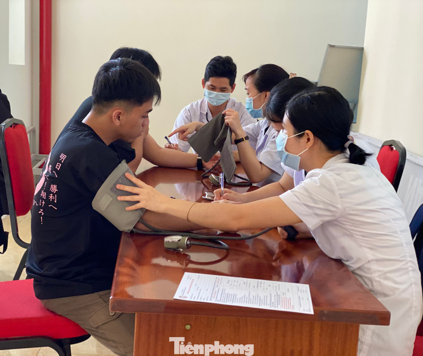 Mọi người xếp hàng, chờ tới lượt để được kiểm tra sức khỏe